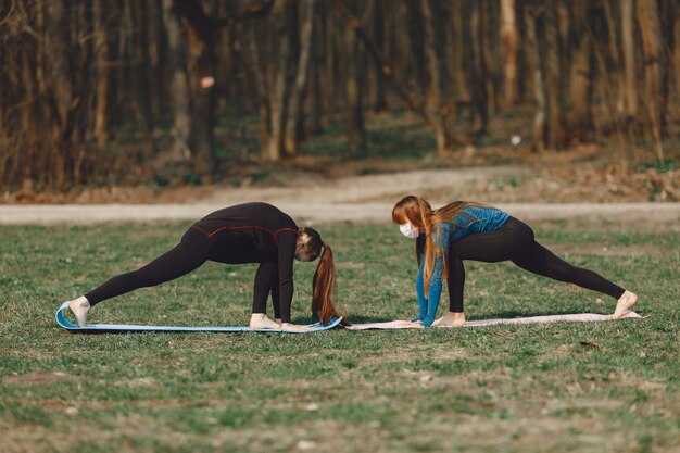 Ragazze sveglie che fanno yoga in maschere