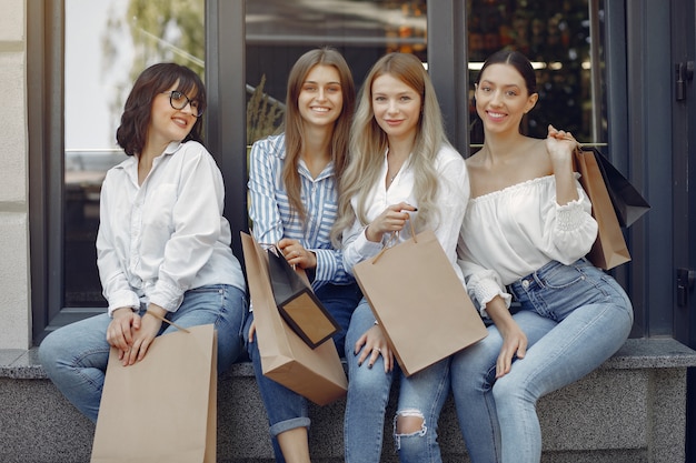 Ragazze sveglie con il sacchetto della spesa in una città