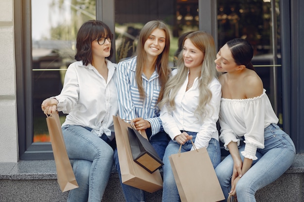 Ragazze sveglie con il sacchetto della spesa in una città