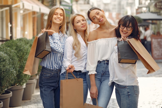 Ragazze sveglie con il sacchetto della spesa in una città