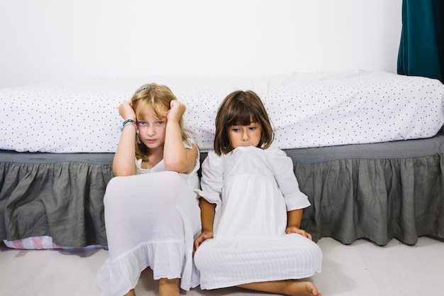 Ragazze tristi vicino al letto