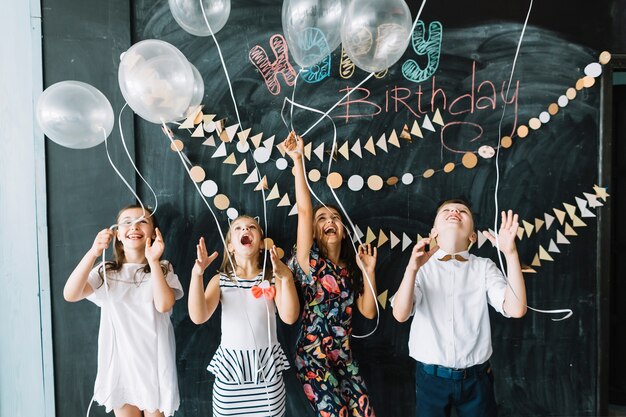 Ragazzi eccitati che rilasciano palloncini in festa