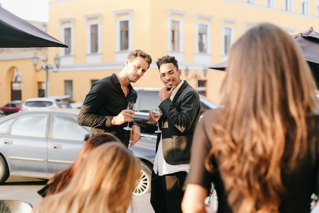 Ragazzi interessati a parlare per strada e guardando la donna bionda che cammina accanto