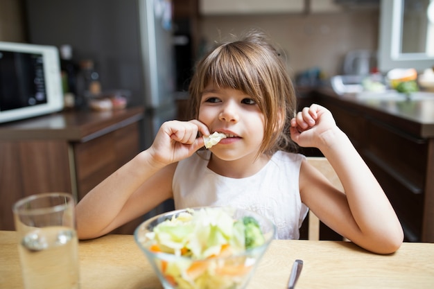 Ragazzina che mangia cibo sano a casa