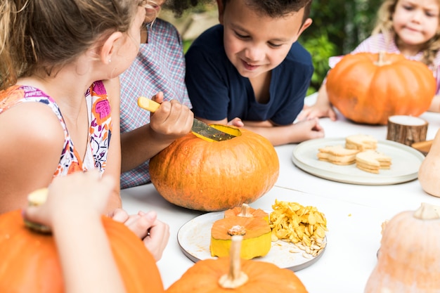 Ragazzini che intagliano Halloween jack-o-lanterne