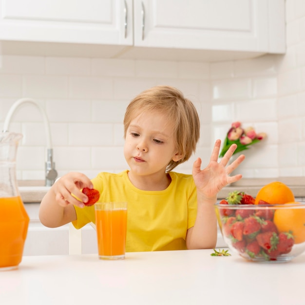 Ragazzino a casa che beve il succo