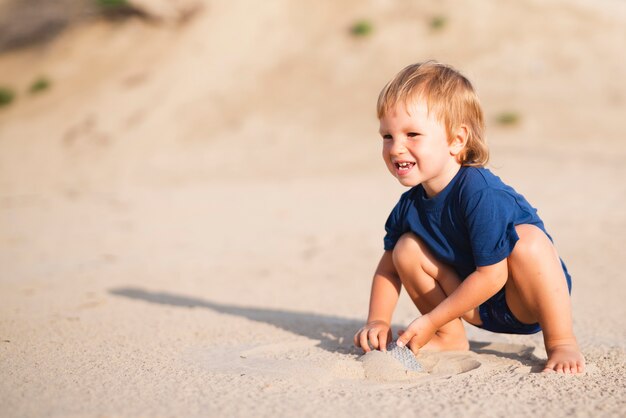 Ragazzino alla spiaggia che osserva via