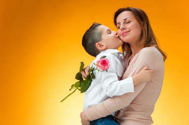 Ragazzino che dà rosa rossa a sua mamma