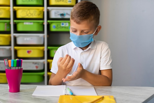 Ragazzino che disinfetta le sue mani