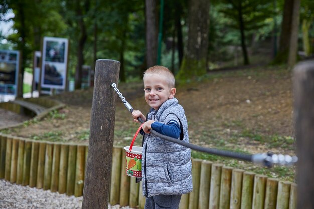 Ragazzino che gioca sulle barre orizzontali nel parco giochi