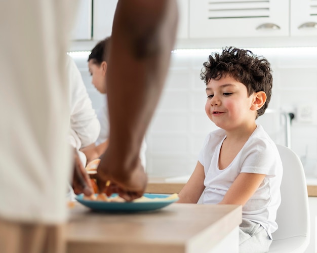 Ragazzino che mangia la colazione preparata da suo padre