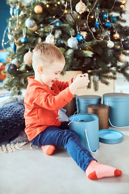 Ragazzino che sembra felice disimballaggio dei regali di Natale