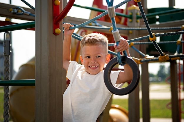 Ragazzino che si diverte al parco giochi all'aperto