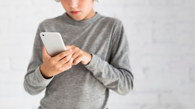 Ragazzino che si diverte con smartphone e auricolari