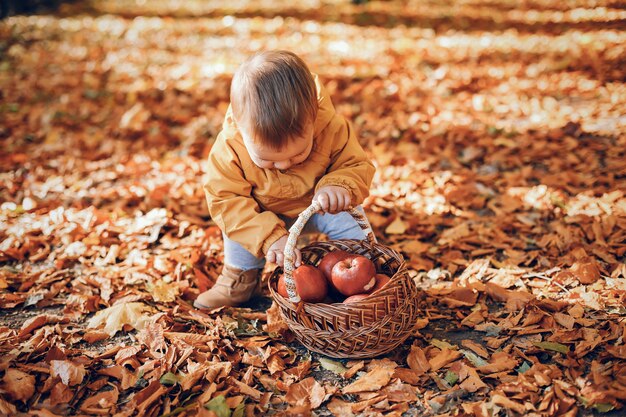 Ragazzino che si siede in una sosta di autunno