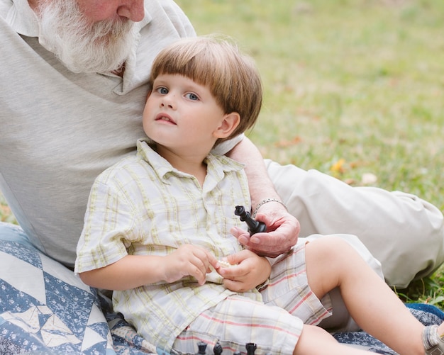 Ragazzino del primo piano con il nonno che esamina macchina fotografica