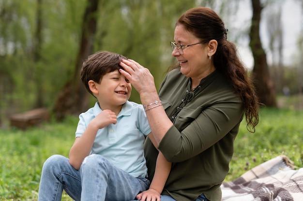 Ragazzino seduto nel parco con sua nonna