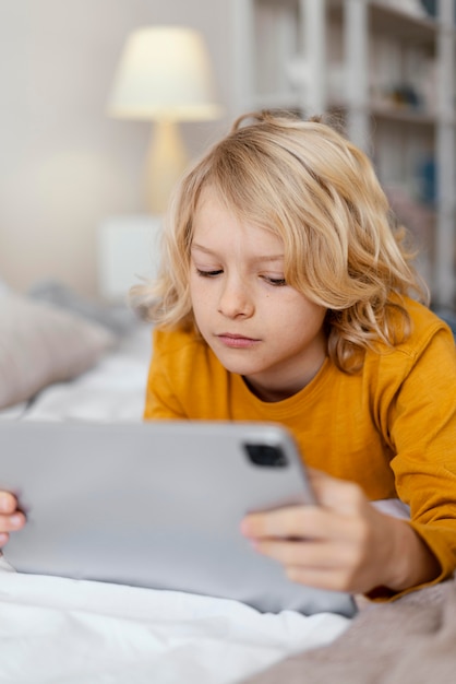 Ragazzo a letto utilizzando tablet