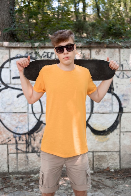 Ragazzo adolescente colpo medio con lo skateboard