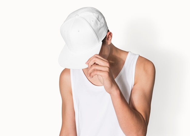 Ragazzo adolescente in berretto snapback bianco e canotta street fashion shoot