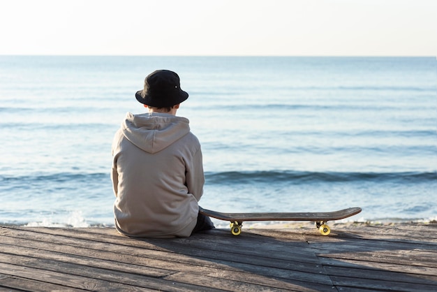 Ragazzo adolescente vista posteriore con lo skateboard