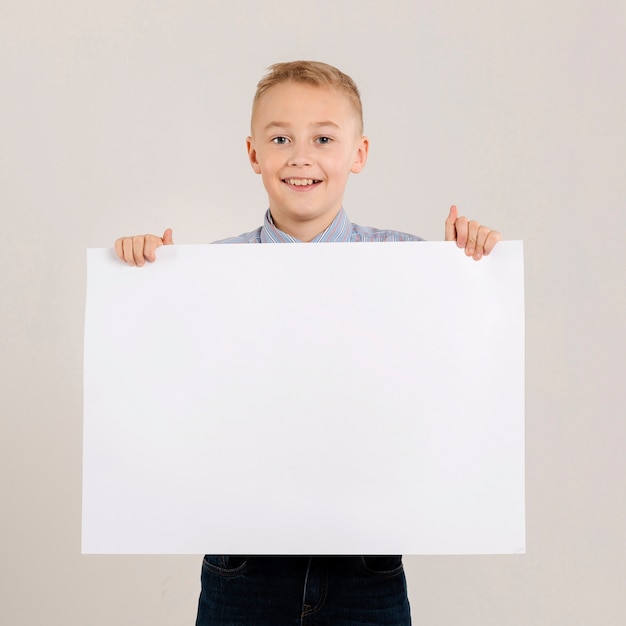 Ragazzo adorabile che tiene carta in bianco