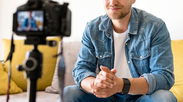 Ragazzo adulto che registra per il suo blog personale a casa