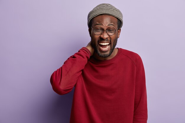 Ragazzo afroamericano che indossa camicia rossa e cappello alla moda