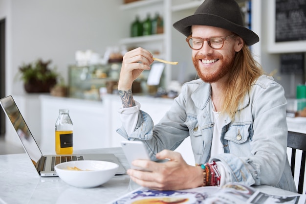 Ragazzo alla moda hipster vestito con elegante cappello nero e camicia di jeans