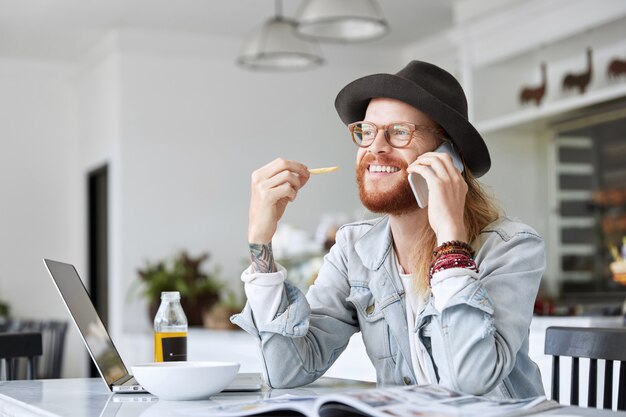 Ragazzo alla moda hipster vestito con elegante cappello nero e camicia di jeans