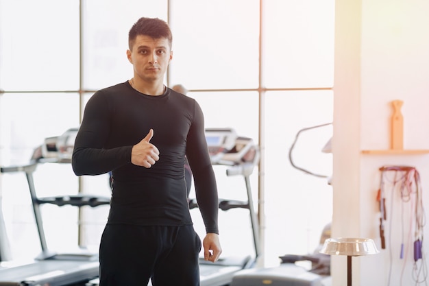 Ragazzo alla moda in palestra in posa per una foto