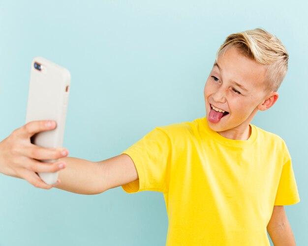 Ragazzo allegro di vista frontale che prende selfie