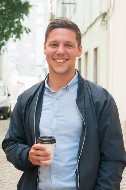 Ragazzo allegro godendo la pausa caffè all&#39;aperto