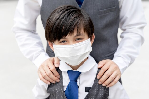 Ragazzo asiatico che indossa una maschera protettiva per la protezione durante l'epidemia di quarantena di Coronavirus covid 19