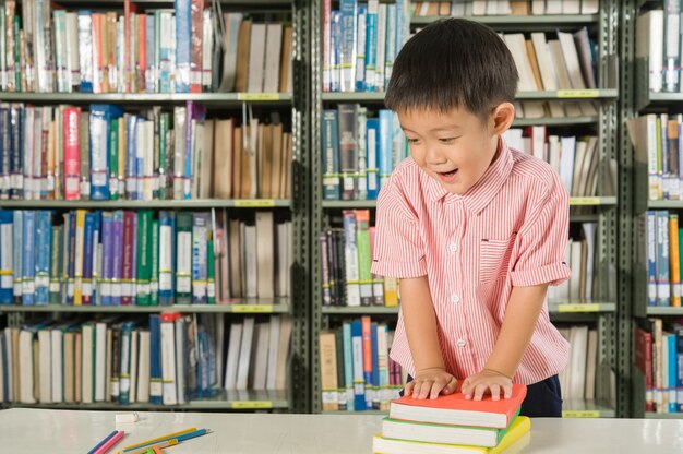 Ragazzo asiatico nella scuola della stanza della biblioteca