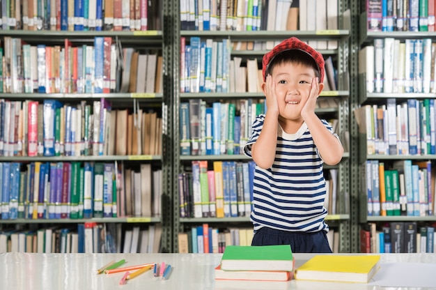 Ragazzo asiatico nella scuola della stanza della biblioteca