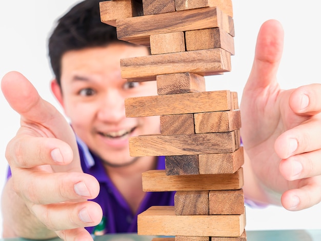 Ragazzo asiatico sta giocando a jenga, un gioco di torre di blocchi di legno