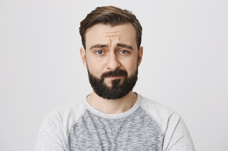 Foto gratuito ragazzo barbuto preoccupato che si sente preoccupato