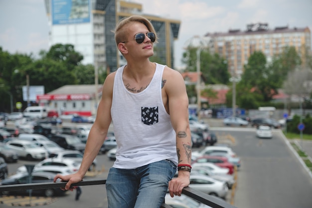 Ragazzo biondo hipster ritratto con tatuaggi e capelli alla moda