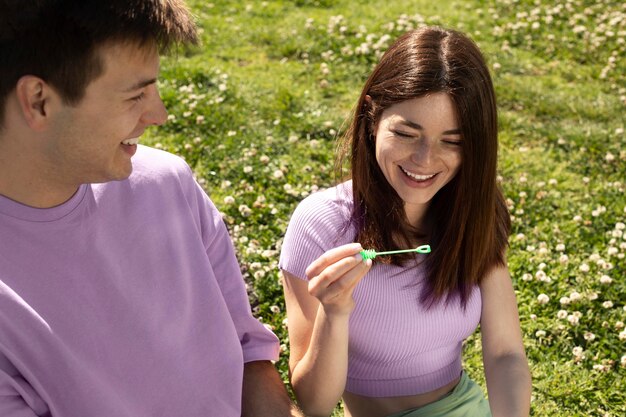 Ragazzo carino e ragazza che giocano con le bolle di sapone