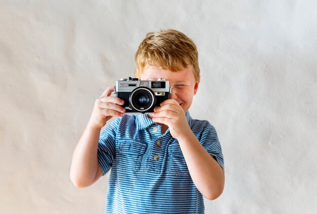 Ragazzo caucasico che gioca con una macchina fotografica