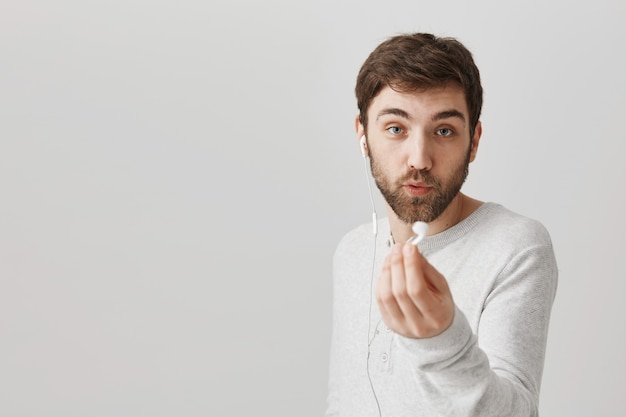 Ragazzo che condivide gli auricolari per ascoltare la musica insieme