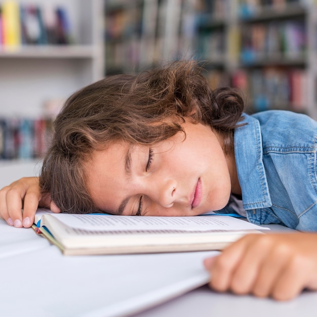 Ragazzo che dorme sul suo taccuino dopo aver fatto i compiti