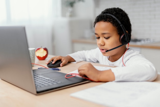 Ragazzo che fa i compiti con l'uso del computer portatile