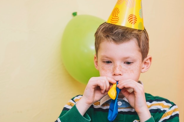 Ragazzo che fa scoppiare i palloncini per la festa di compleanno