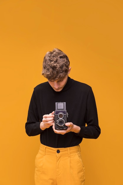 Ragazzo che filma con una videocamera in una scena gialla