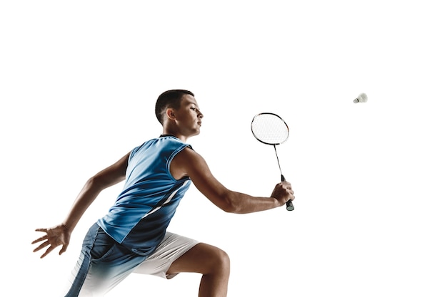 Ragazzo che gioca a badminton isolato sul muro bianco.