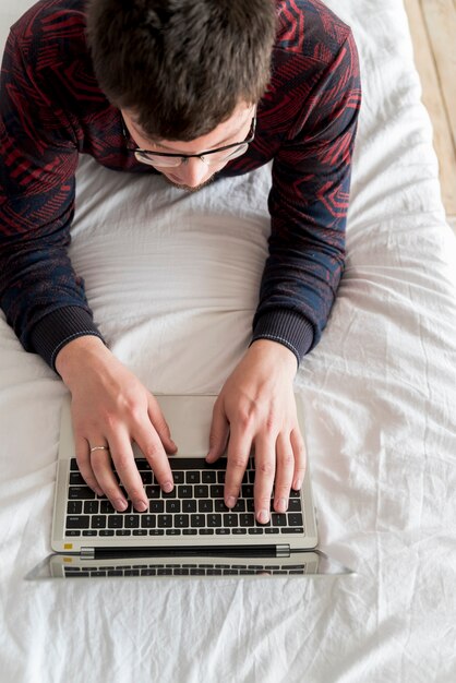 Ragazzo che lavora al computer portatile grigio