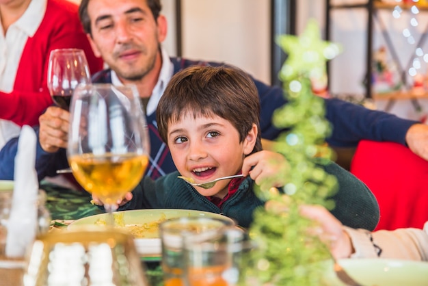 Ragazzo che mangia al tavolo festivo