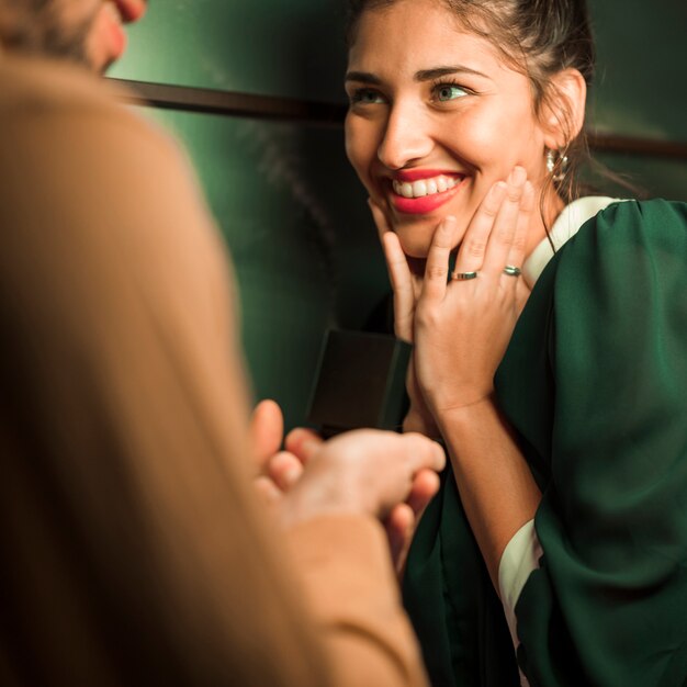 Ragazzo che presenta regalo in scatola per attraente signora felice